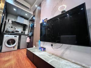 a large flat screen tv on a wall in a kitchen at Sleep Cubee Hostel in Hong Kong