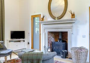 a living room with a fireplace and a mirror at Palmers Folly in Wells next the Sea