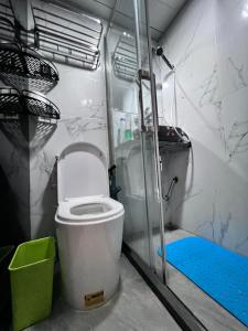 a small bathroom with a toilet and a shower at Sleep Cubee Hostel in Hong Kong