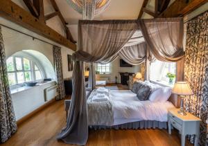 a bedroom with a canopy bed with a large window at The Triumphal Arch West in Holkham