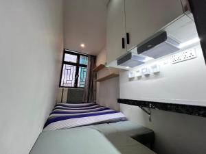 a small room with a bed and a window at Sleep Cubee Hostel in Hong Kong
