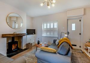 a living room with a blue couch and a mirror at Quay View Cottage in Wells next the Sea