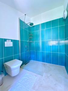 a bathroom with a toilet and a shower with blue tiles at Akdeniz Villa in Kas