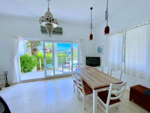 a dining room with a wooden table and chairs at AkdenizVillas in Kaş