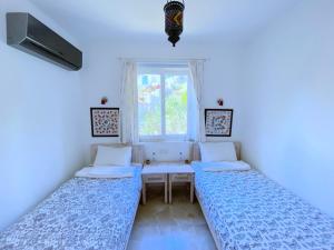 a room with two beds and a window at Akdeniz Villa in Kas