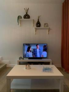 a living room with a tv and a table at Paraíso Maspalomas Experience in San Bartolomé