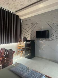 a living room with chairs and a television on a wall at Nhà Nghỉ A&Em in Xã Bình Hòa +28 photos