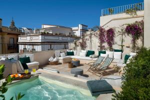 a rooftop patio with a pool and furniture on a building at Casa del Rey Sabio in Seville