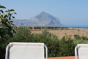 uma vista para uma montanha à distância com duas cadeiras em VILLA FLAMINIA - con piscina privata em San Vito lo Capo