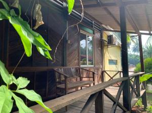 a porch of a wooden house with a bench at Fusion Villa in Bedung