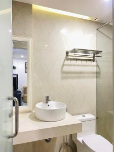 W łazience znajduje się umywalka, toaleta i lustro. w obiekcie Khách sạn căn hộ Sentosa Coco w mieście Hà Quảng (4)