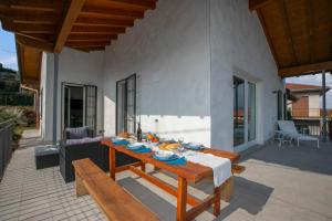 eine Terrasse mit einem Tisch und Bänken an einem Haus in der Unterkunft Villa Laura Private Pool and Garden in Besozzo