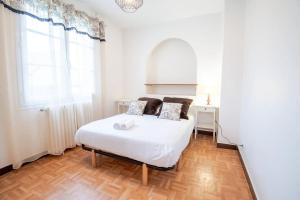 um quarto branco com uma cama e uma janela em Parenthèse champêtre : Maison 7 pers. em Truyes