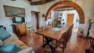 ein Wohnzimmer mit einem Holztisch und einem Sofa in der Unterkunft Casale Alcinoo - Rustico in Tuoro sul Trasimeno