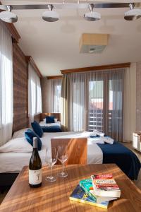 Central Inn في زلاتيبور: غرفة في الفندق بسريرين وطاولة مع كؤوس للنبيذ