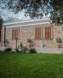 Sonnino的住宿－Agriturismo Country Casale Rufo，一座石头建筑,设有棕色的窗户和庭院