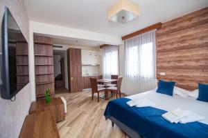 a hotel room with a bed and a dining room at Central Inn in Zlatibor