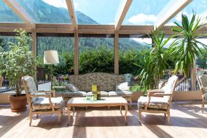 Una sala de estar con sillas, una mesa y un sofá. en Hotel Alpenhof, en Sankt Jakob in Defereggen