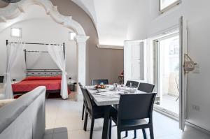 ナルドにあるLa Torretta - Nardò Charming Apartmentのテーブルと椅子とベッドのあるダイニングルーム