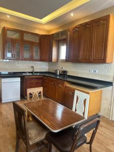 eine Küche mit Holzschränken und einem Holztisch in der Unterkunft Dreamland villa in ‘Ezbet `Abd el-Ḥamîd