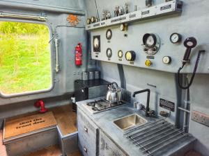 a kitchen with a stove and a sink in an rv at The Yellow Submarine in Cheddar