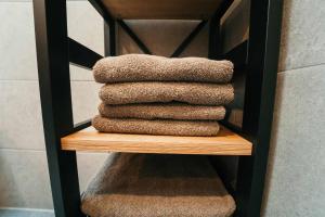 リムバッハにあるWohlfühlzeit Naturdesign Chalet`sの木棚にタオルを積み重ねる