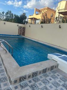 a swimming pool in a villa with blue water at Dreamland villa in ‘Ezbet `Abd el-Ḥamîd