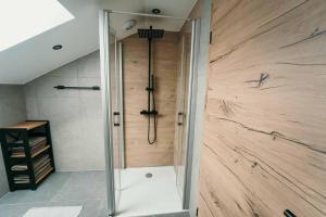 リムバッハにあるWohlfühlzeit Naturdesign Chalet`sの木製の壁がある浴室のシャワー
