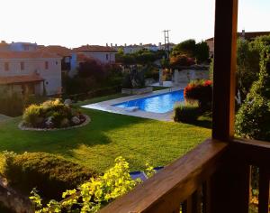 a view from a balcony of a yard with a swimming pool at Alexander Dion House in Afitos