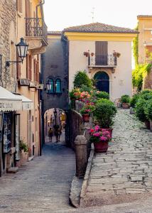 un callejón con macetas y edificios en una calle en antica bifora rsm, en San Marino