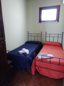 2 camas individuales en una habitación con ventana en Casa vacanze BY THE SEA en Trabia