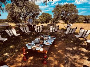 a table with plates of food on it with chairs at Hotel Valdepalacios Gourmand 5* GL in Torrico