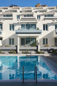 a building with a swimming pool in front of a building at Mariposa Del Sol in Patalavaca