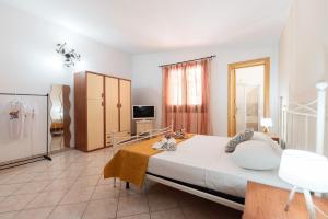 a large bedroom with a large bed and a tv at Villa Minoa con piscina in San Vito lo Capo
