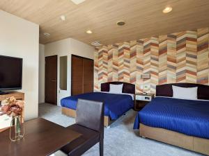 a hotel room with two beds and a television at Hotel New Gaea Yakuin in Fukuoka