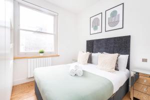 una camera da letto con un grande letto con due scarpe bianche di Central London Soho Suite - CityApartmentStay a Londra