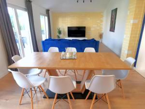 a dining room table with white chairs and a blue table cloth at ''Bjonda'' 200m2 on two floors - Game Room, Hot Tub and Kids Zone - large balconies on each floor in Mlini