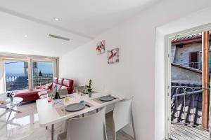 ein weißes Wohnzimmer mit einem weißen Tisch und Stühlen in der Unterkunft Red View Apartment - Happy Rentals in Ronco sopra Ascona