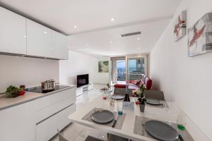 eine Küche und ein Wohnzimmer mit einer Theke und einem Tisch in der Unterkunft Red View Apartment - Happy Rentals in Ronco sopra Ascona