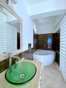 ein Badezimmer mit einem grünen Waschbecken und einer Badewanne in der Unterkunft Akdeniz Villa in Kaş