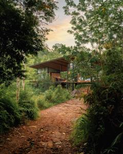 ein Haus inmitten einer unbefestigten Straße in der Unterkunft Kurunduketiya Private Rainforest Resort in Kalawana