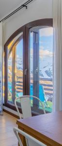a room with a table and chairs and a large window at Templo cota 2330m in Sierra Nevada