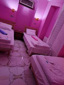 duas camas num quarto com iluminação rosa em Hostel Panda em Tbilisi