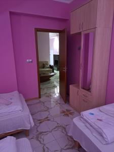 um quarto roxo com 2 camas e um espelho em Hostel Panda em Tbilisi