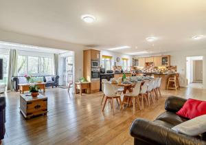 a living room and kitchen with a table and chairs at Waters Edge in Pentney