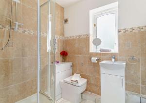 a bathroom with a toilet and a glass shower at Waters Edge in Pentney