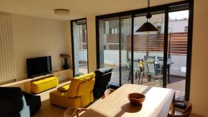 een woonkamer met een eettafel en gele stoelen bij Rutlla 10 in Girona