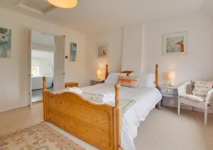a bedroom with a large bed and a chair at Peddars Rest in Sedgeford