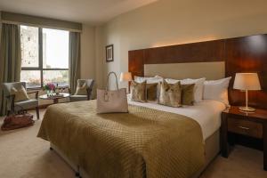 una habitación de hotel con una cama grande con una bolsa. en Trim Castle Hotel, en Trim