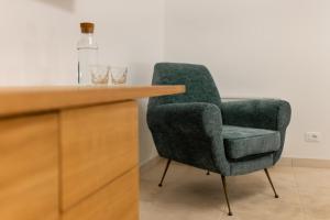 莫诺波利Il Pumo Verde by MONHOLIDAY的一张坐在柜台旁的绿色椅子